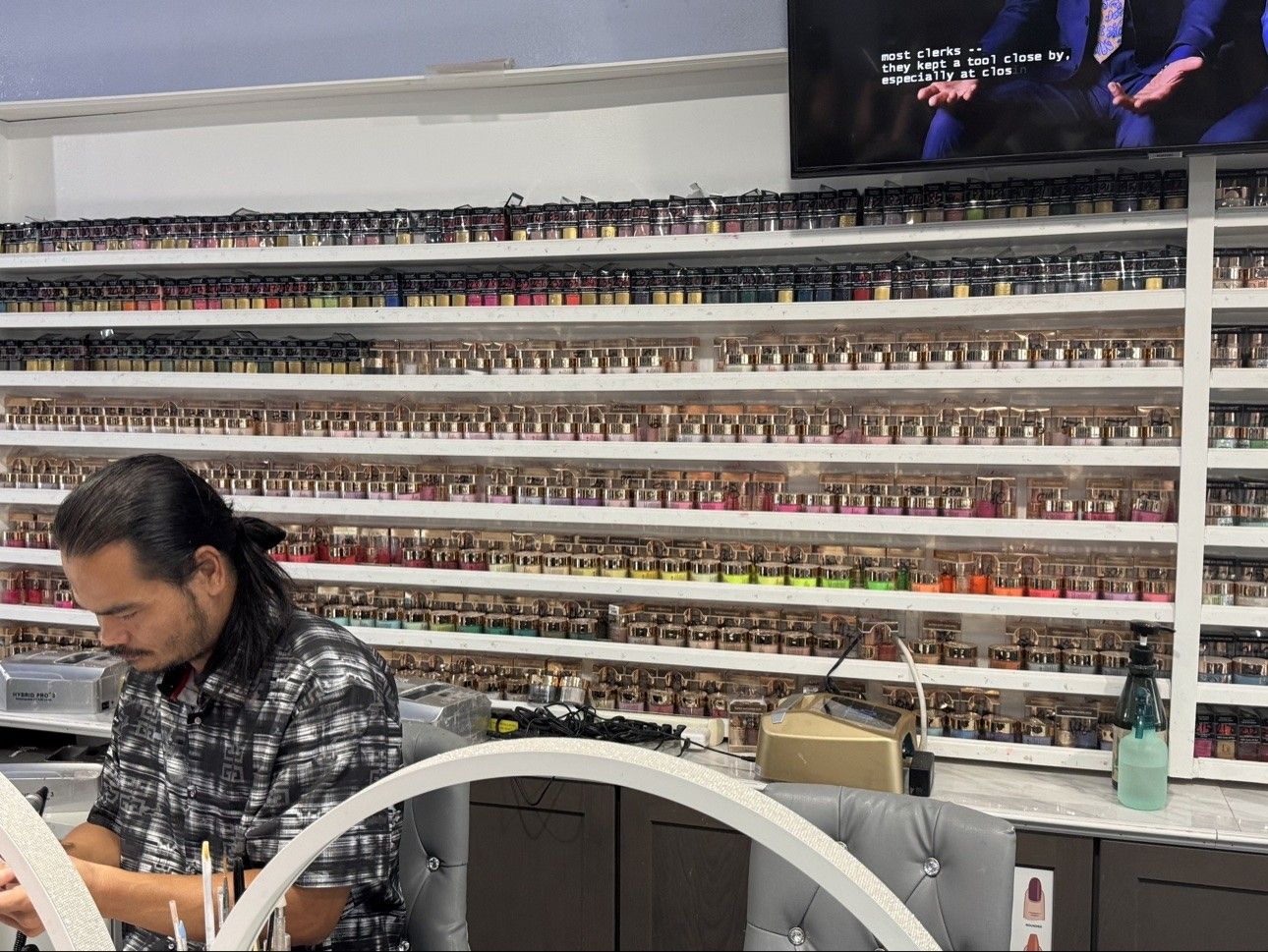 Color wall at a workstation at Euro Nail Lounge — dip powder shelves at a nail technician's desk
