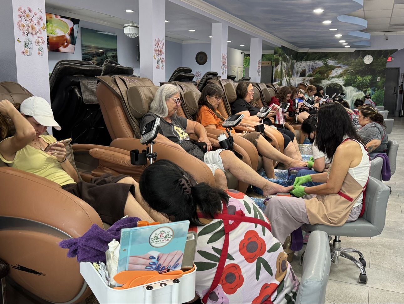 Guests relaxing in massage chairs at Euro Nail Lounge