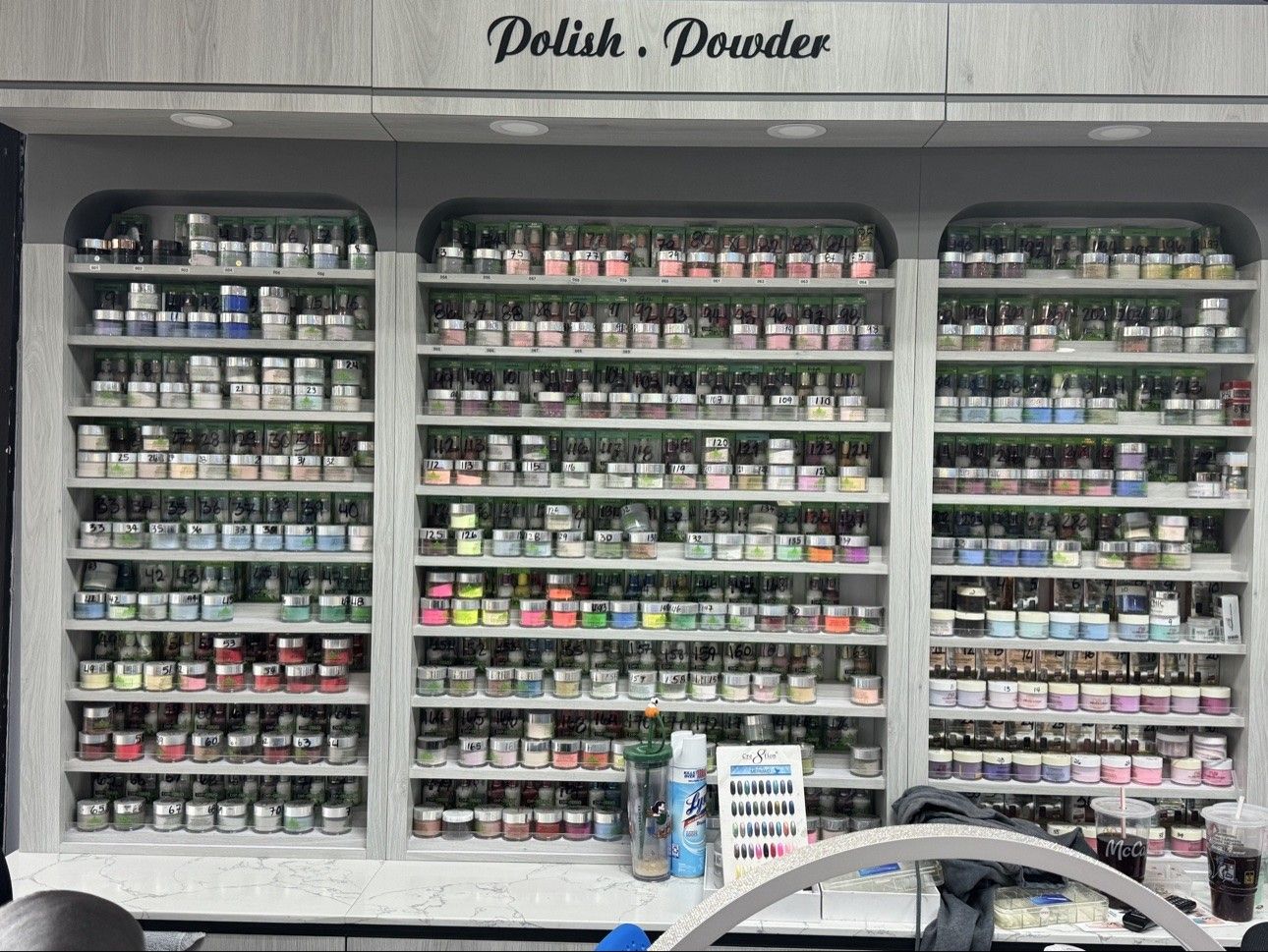 Polish and powder wall at Euro Nail Lounge — numbered shelves of polish and dip powder shades