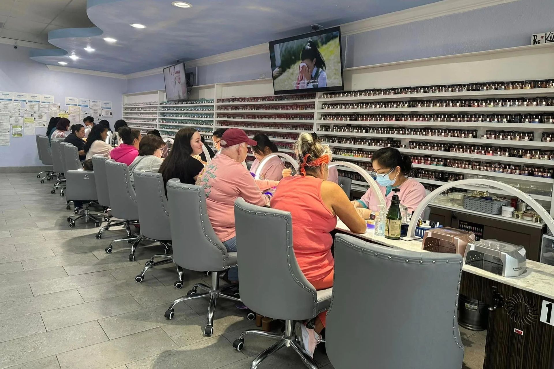 Inside Euro Nail Lounge — manicure stations in front of the wall of nail polish colors