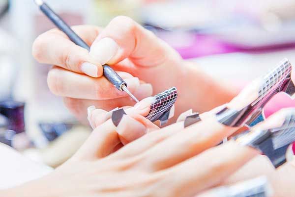Nail enhancements at Euro Nail Lounge — technician applying acrylic nail extensions with nail forms