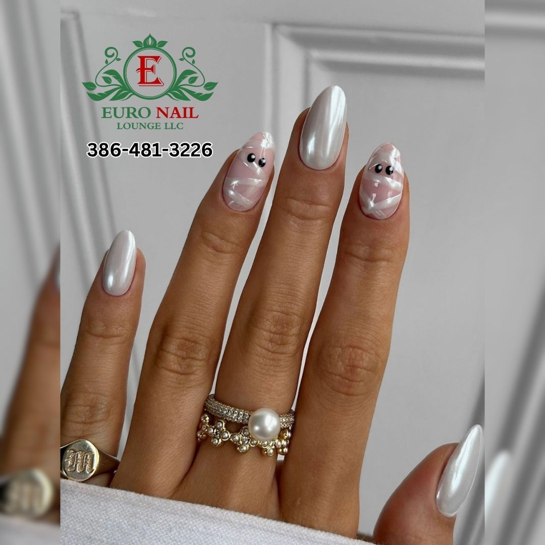 Pearly chrome almond nails at Euro Nail Lounge — pearly white chrome almond nails with mummy-ghost accent nails