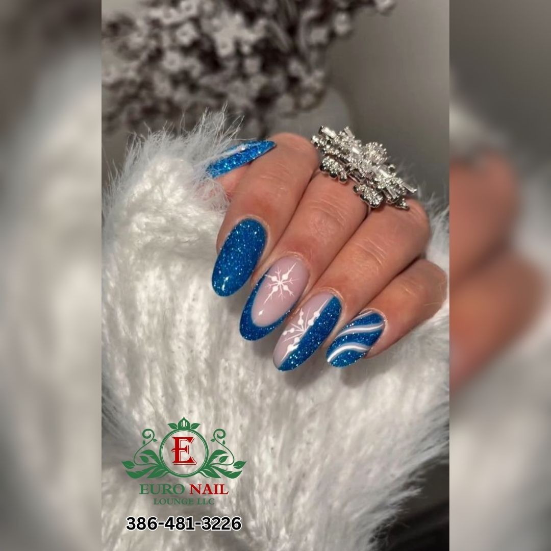 Blue glitter snowflake nails at Euro Nail Lounge — blue glitter nails with white snowflake designs
