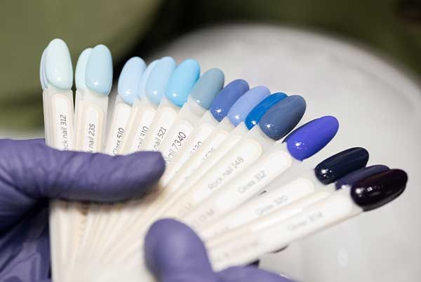 Nail art and extras at Euro Nail Lounge — fan of blue nail polish color swatches held by a technician